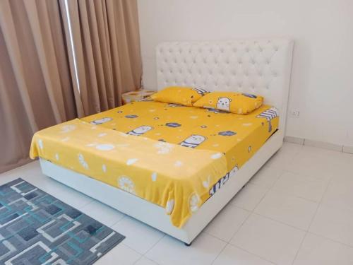 Camellia Homestay Semenyih في سيمينيه: سرير مع لحاف ووسائد صفراء عليه