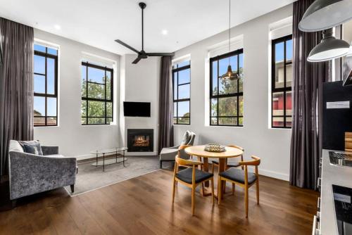 a living room with a table and chairs and a fireplace at Manhattan on Moorabool - Heritage Listed Geelong CBD in Geelong