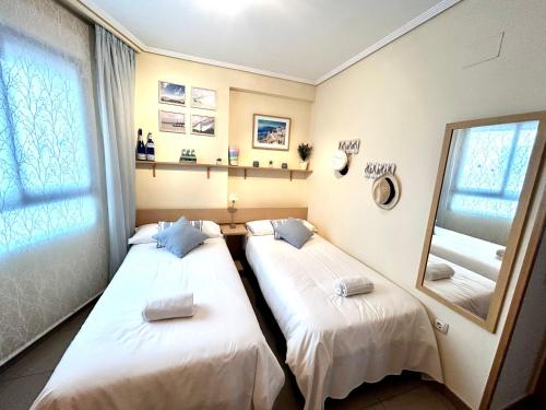 - 2 lits dans une chambre avec un miroir dans l'établissement RESORT BEACH VALENCIA, à Valence