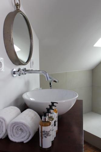 a bathroom with a sink and a mirror and towels at Palácio do Visconde - The Coffee Experience in Lisbon