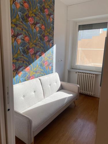 ein Wohnzimmer mit einer weißen Couch und einer Blumentapete in der Unterkunft Labanca's Luxury center in Matera