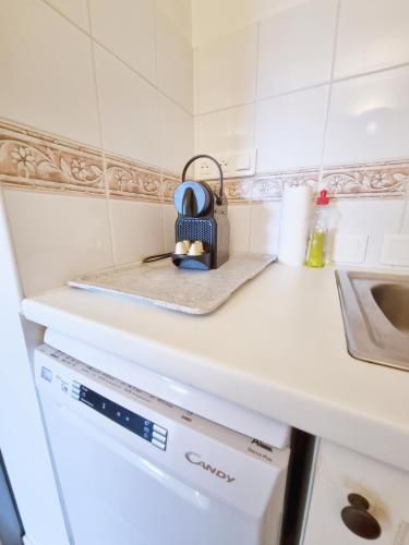 - une cuisine avec un comptoir blanc et un lave-vaisselle dans l'établissement La Pinède - T4 avec terrasse et piscine, au Lavandou