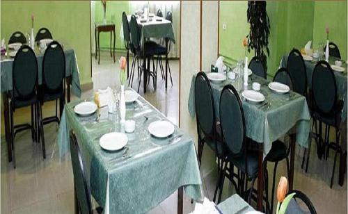 two pictures of a dining room with tables and chairs at Conord Hotel - "Amman's Heart" in Amman