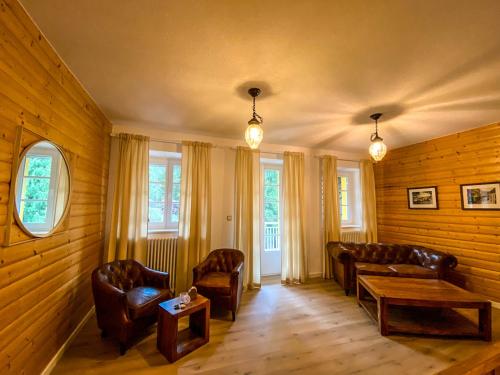 a living room with leather furniture and windows at Luxusvilla Österreich in Scheibbs