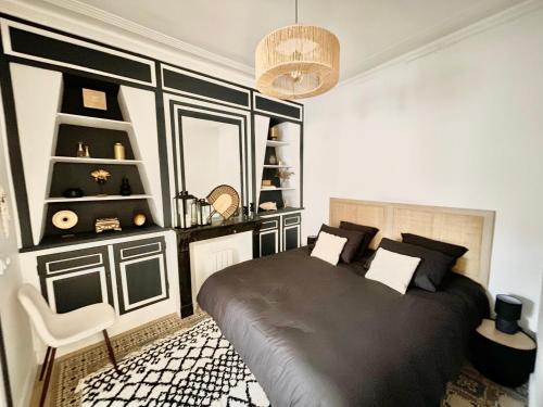 - une chambre avec un lit noir et une chaise dans l'établissement L'Art appart' - T2 - Lit King Size - Proche centre, à Amiens