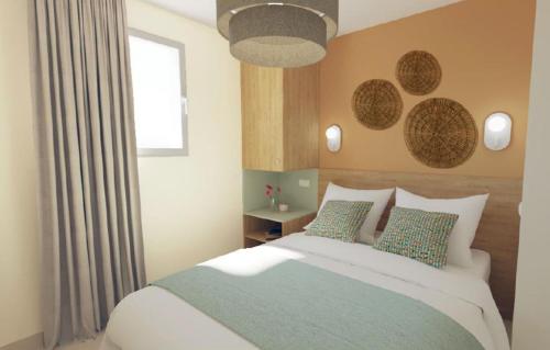 una camera con un grande letto e una finestra di Résidence Prestige Odalys Le Riviera a Hyères