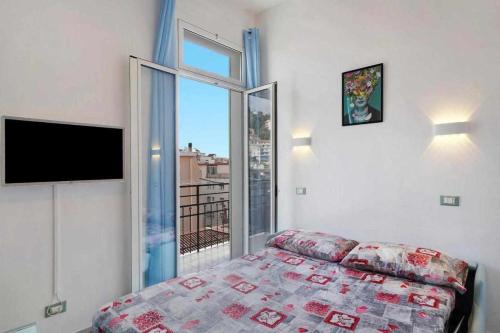 ein Schlafzimmer mit einem Bett und einem großen Fenster in der Unterkunft Frida apartments in Sanremo