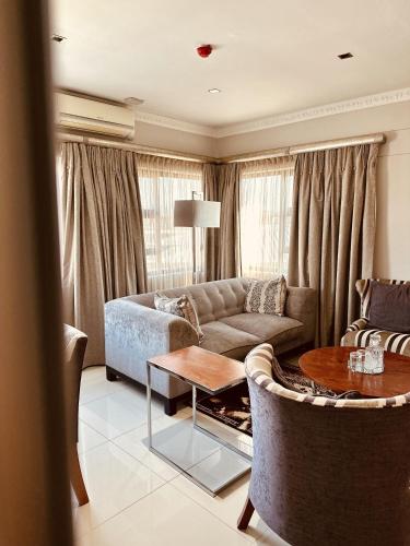 a living room with a couch and a table at Hotel Destiny in Ongwediva