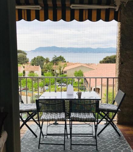 a table and chairs on a balcony with a view at Studio Saint Cyr sur mer,Vue mer in Saint-Cyr-sur-Mer