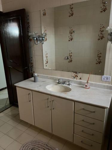 uma casa de banho com um lavatório e um espelho em Pousada cravo & canela em Maringá