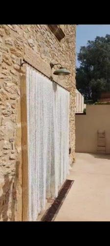 a stone wall with a white curtain on it at Mas Ferran Adults Only in Pals