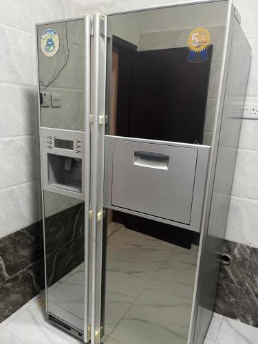 a refrigerator with a glass door in a room at تاج الكورنيش عجمان in Ajman 