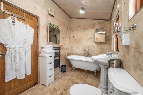 a bathroom with a tub and a sink and a toilet at Muir-lan cabin in Lochinver