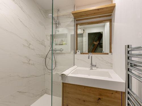 une salle de bain avec un lavabo et une douche en verre dans l'établissement Charmant studio avec mezzanine, balcon Sud/Ouest, Wifi, proche centre Val-d'Isère - FR-1-694-314, à Val dʼIsère