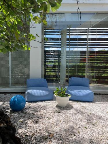 a patio with two blue pillows and a plant at New Kuta Suites in Jimbaran