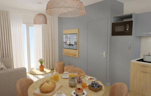 - un salon avec une table et de la nourriture dans l'établissement Résidence Prestige Odalys L'Orée du Parc, à Royan