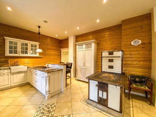 a kitchen with white appliances and wooden walls at Luxusvilla Österreich in Scheibbs