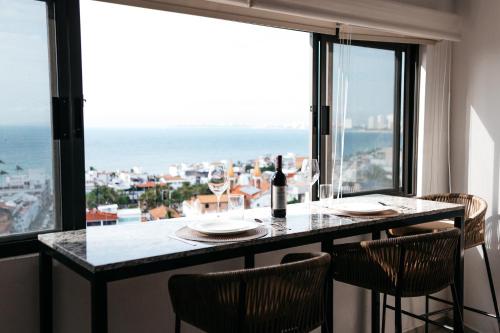 Monyxbnb Hotel في بويرتو فايارتا: غرفة طعام مع طاولة مطلة على المحيط