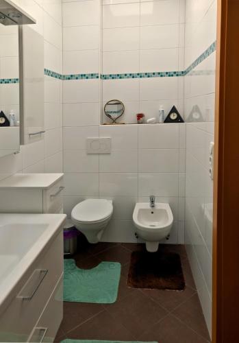 a white bathroom with a toilet and a sink at Bungalow Lindenweg in Bad Ischl