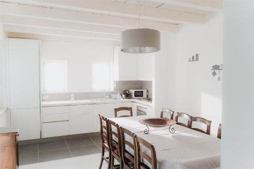a white kitchen with a table and chairs at Civiconr3 in Sona