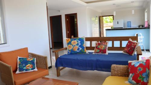 a living room with a couch and a bed with pillows at CasAmarela in Santa Cruz Cabrália