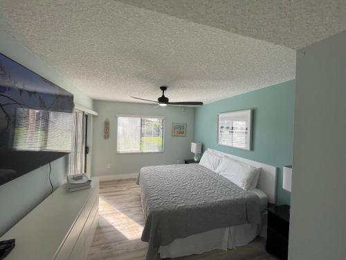 a bedroom with a bed and two windows at Ocean Village Club in Saint Augustine