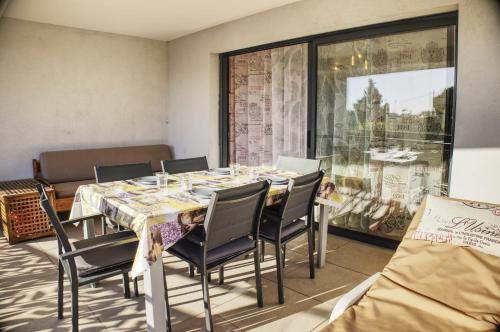 uma sala de jantar com mesa e cadeiras em le verger des naiades em Le Lavandou