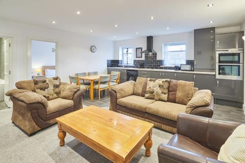 a living room with couches and a table and a kitchen at Jackson Court Apartment 3 in Marske-by-the-Sea