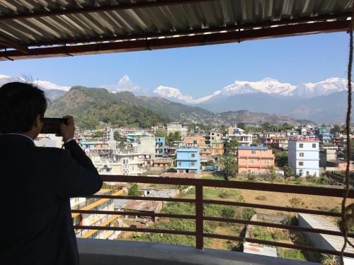 Ein Mann, der eine Stadt fotografiert. in der Unterkunft Hotel Sheron Lilyland in Pokhara