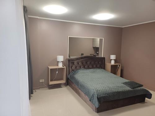 ein Schlafzimmer mit einem Bett und einem großen Spiegel in der Unterkunft Lambertu ielas rezidence in Mārupe
