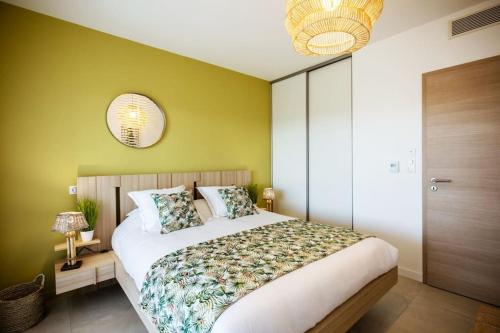 une chambre avec un grand lit aux murs verts dans l'établissement Appt 2 chambres, neuf proche de toutes commodités., à Porto-Vecchio