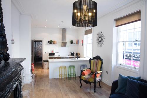 a living room with a chair and a kitchen at Richmond Apartment in Liverpool