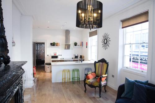Una sala de estar con una silla y una cocina. en Richmond Apartment, en Liverpool