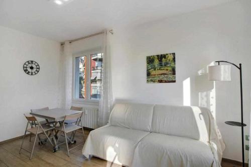 a white living room with a couch and a table at Ninfea apartments in Sanremo
