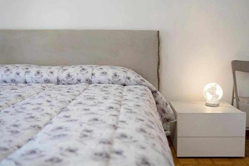 a bedroom with a bed and a nightstand with a lamp at Ninfea apartments in Sanremo