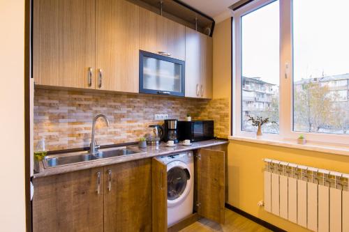 a kitchen with a sink and a washing machine at hotelise l Verde Apartment in Yerevan