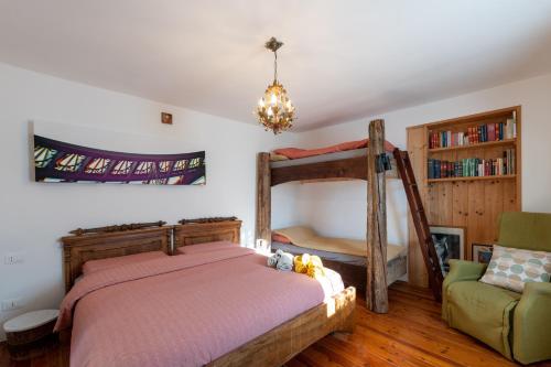 a bedroom with a bunk bed and a chair at Casa Vacanze Zummer Frei Studio in Pieve di Cadore