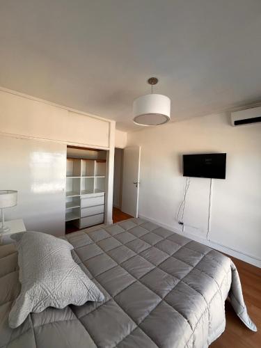 a bedroom with a large bed and a flat screen tv at Departamento vista al mar in Necochea