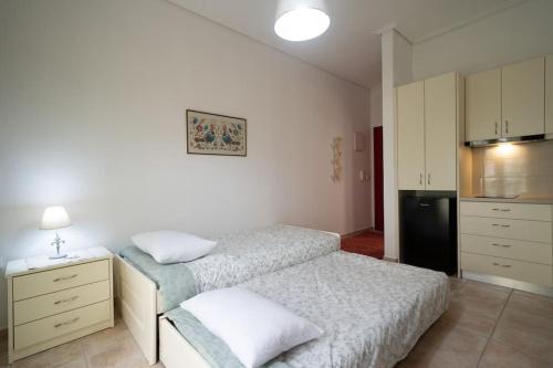 a small bedroom with two beds and a refrigerator at Delphian Colors - Red Edition in Delfoi