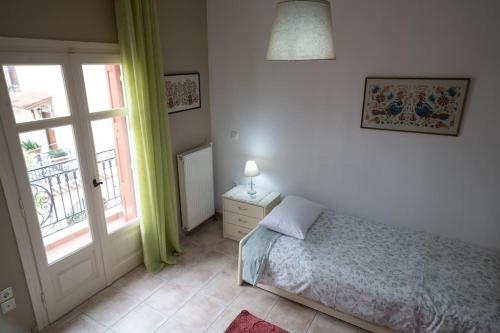 a bedroom with a bed and a window and a door at Delphian Colors - Red Edition in Delfoi