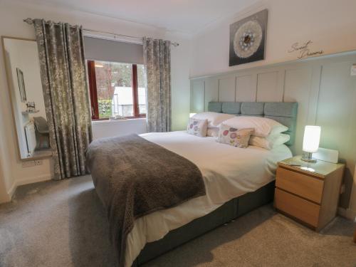ein Schlafzimmer mit einem großen Bett und einem Fenster in der Unterkunft Hollys Hideaway in Castle Douglas