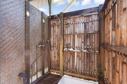 uma casa de banho com uma parede de madeira e um chuveiro em Tropica Bliss: 2.5km to CBD em Stuart Park