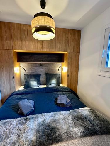 une chambre avec un grand lit avec une couette bleue dans l'établissement Ecrin Alpin hyper centre d'Auron, à Saint-Étienne-de-Tinée