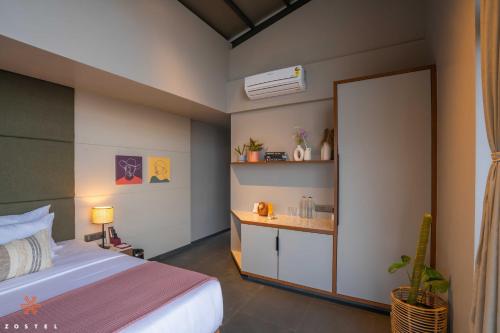 a bedroom with a bed and a sink at Zostel Plus Panchgani in Panchgani