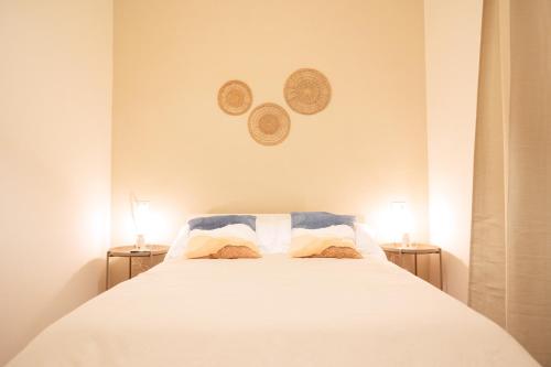 a bedroom with a white bed with two lamps at La Bifora in Tivoli