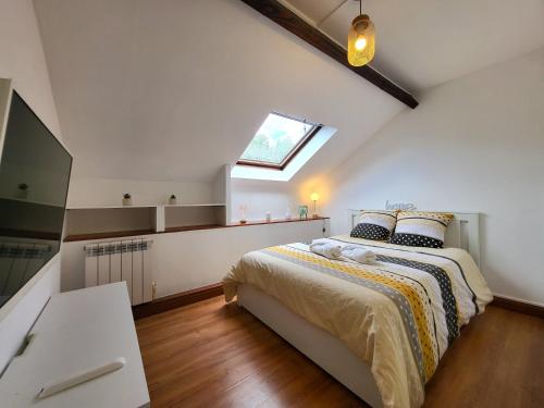 ein Schlafzimmer mit einem Bett und einem Dachfenster in der Unterkunft Le Nouvo : bel appartement entièrement rénové in Corbeil-Essonnes