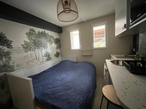 - une petite chambre avec un lit bleu dans l'angle dans l'établissement La Baule Beach Box, petite studette bord de mer, à La Baule