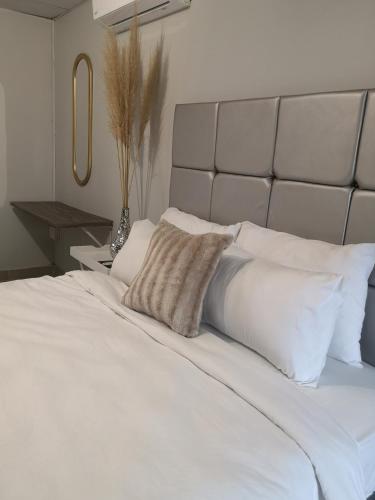 1 cama blanca grande con almohadas blancas en Boontjieskraal, en Kimberley