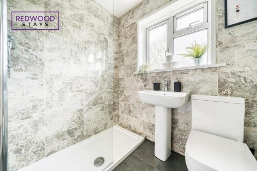 a bathroom with a sink and a toilet and a tub at 2 Bed 1 Bath House, Perfect for Corporate, Contractors & Families x2 FREE Parking, Garden, Netflix By REDWOOD STAYS in Alton