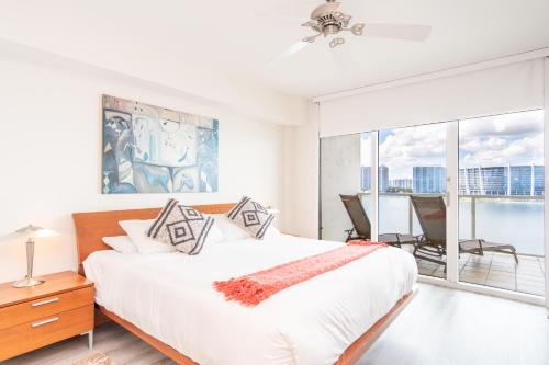 een witte slaapkamer met een groot bed en een balkon bij Marina Bay 108 in Miami Beach